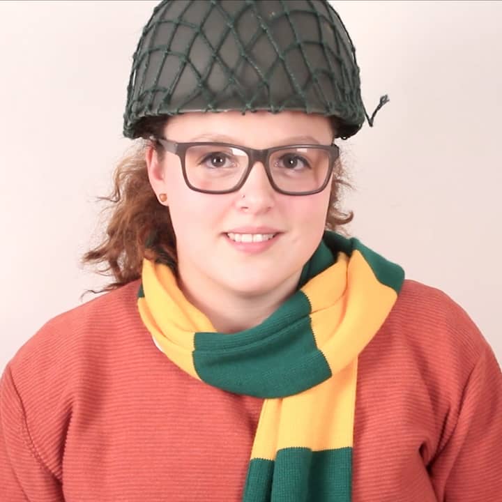 Portrait of Bethany wearing army helmet and green and yellow patterned scarf